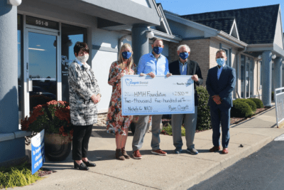 Dr. Clagett and the Clagett Dental Team Holding Up Donation Check for the HMH Foundation