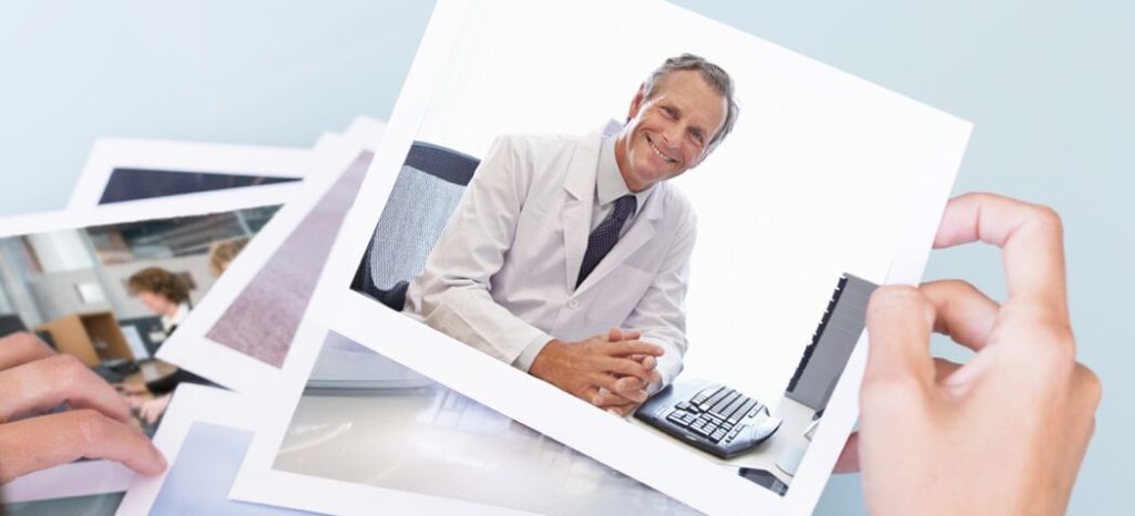 Image of a doctor smiling in front of a computer